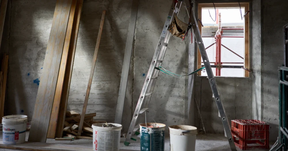 Stege och färghinkar i ett rum under renovering